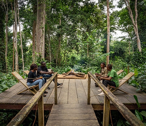 People sitting near a campfire at Camp Imbalanga